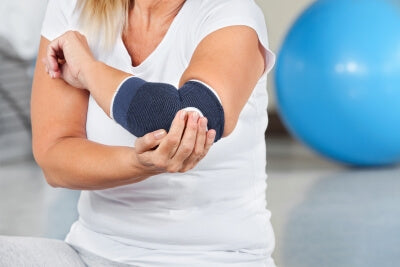 Mujer con dolor articular lleva una codera