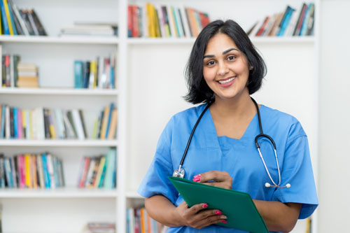 Mujer joven sonríe y lleva ropa médica clásica azul